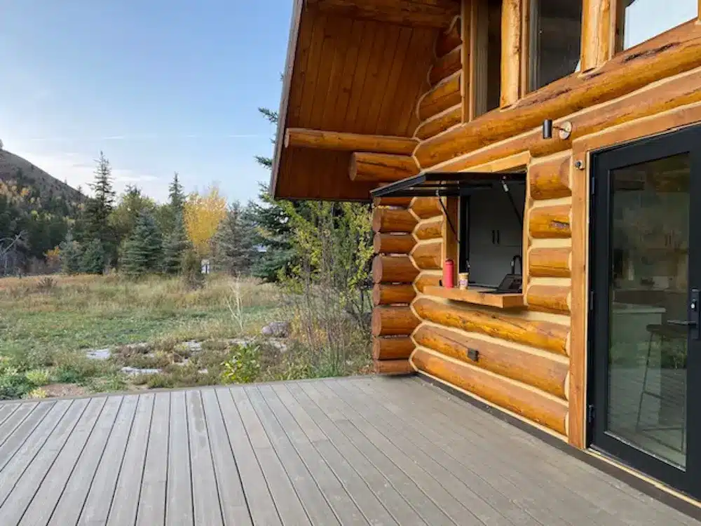 OpenUp Windows gas strut awning window enhances the view in a mountain cabin.